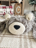 A gray grizzly bear rug made by ClaraLoo with crochet accents in a woodland themed nursery.