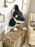 A plush Orca Wall Mount handmade by ClaraLoo in an ocean themed nursery. This stuffed sea animal is made of soft black and white faux fur with crocheted accents. This plush orca is mounted on a white wooden plaque.