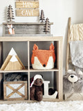 Handmade crocheted Fox Basket sitting on a wooden shelf. The fox basket is orange and white with a black nose.